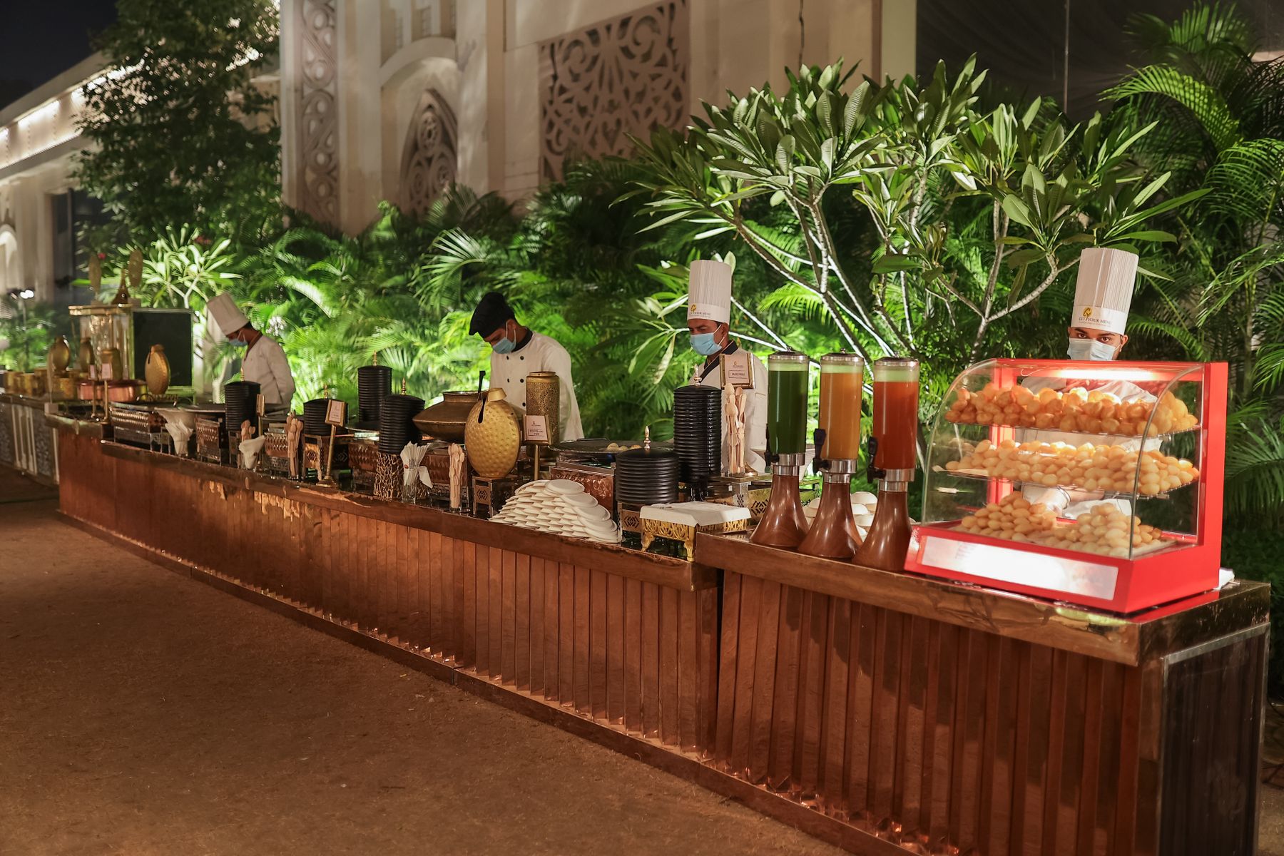 Chefs staffing an elegant outdoor catering line at night